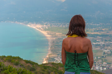 Woman seen from behind looking at a beach in Zakynthos island, Greece