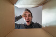 © vchalup - Happy and surprised man is opening a gift and looking inside cardboard box.