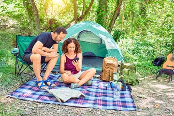 Poster - Middle age couple  of hiker smiling happy camping at the forest. Sitting on the floor using smartphone.