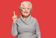 © Krakenimages.com - Senior grey-haired woman wearing casual winter sweater showing and pointing up with finger number one while smiling confident and happy.