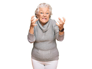 Poster - Senior grey-haired woman wearing casual winter sweater shouting frustrated with rage, hands trying to strangle, yelling mad