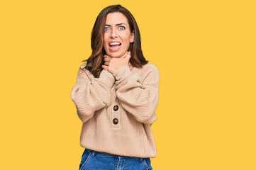 Wall Mural - Young brunette woman wearing casual winter sweater shouting and suffocate because painful strangle. health problem. asphyxiate and suicide concept.