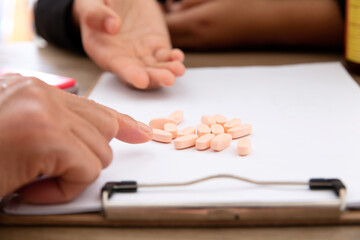 Wall Mural - Two people are analyzing pills on white paper