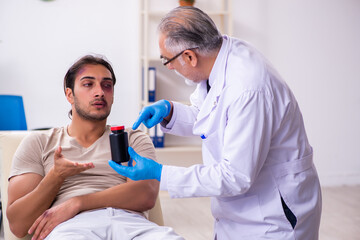 Wall Mural - Young face injured man visiting experienced male doctor traumato