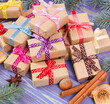 Wrapped gifts with ribbons for Christmas, spices and spruce branches