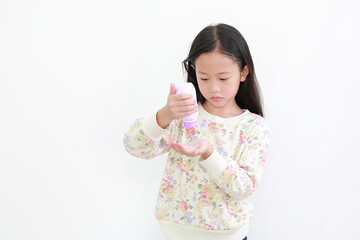 Wall Mural - Little asian girl pouring talcum powder on hand over white background