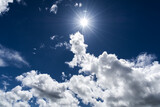 Fototapeta Na sufit - Niebieskie niebo i słońce między chmurami 