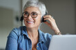 © goodluz - Mature woman with grey short hair working from home during pandemia
