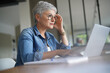 © goodluz - Portrait of a beautiful mature 50-year-old woman with white hair working from home