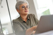 © goodluz - Attractive senior woman working on laptop