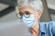 © goodluz - 55-year-old senior woman with white hair working with face mask