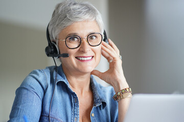 Wall Mural - Mature woman with grey short hair working from home during pandemia