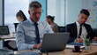 © stockbusters - Serious businessman typing on laptop in open space. Male executive using laptop