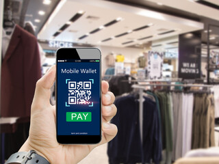 Wall Mural - Moblie wallet payment with qr code concept.Hands holding mobile phone on blurred clothing shop in department store as background