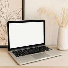 Wall Mural - Laptop computer with blank screen on table with boho decorations. Minimal boho styled interior design template with mockup copy space.
