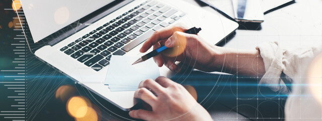 Woman with laptop computer distant working. Writing with the pen. Remote studiyng from home. Lockdown business. Graphics and stats effects overlay. Hands close-up wide screen