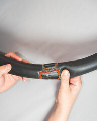 teenager hands holding inflatable chamber for wheels bicycle with patch glued on