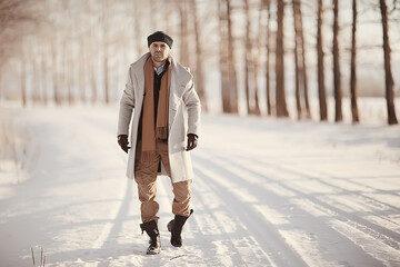 Wall Mural - fashionable man in a coat / winter style, walk against the backdrop of the winter landscape, snowy weather, warm clothes