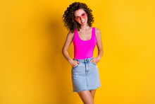 Photo Of Pretty Wavy Hairdo Lady Beaming Smile Hands Pockets Denim Skirt Cool Trend Look Outfit Summer Holidays Wear Heart Shape Sun Glasses Pink Tank Top Isolated Yellow Color Background