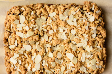 baked rectangular crumble cake with fruit filling on a brown paper background