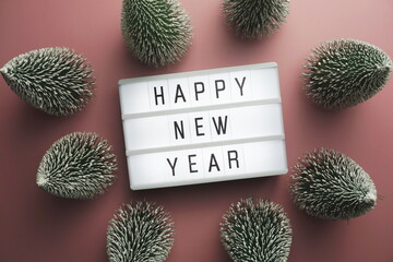 Wall Mural - Happy New Year word in light box with Christmas tree top view on pink background