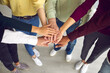 © Studio Romantic - Close-up of business people or friends putting hands together as symbol of cooperation, teamwotk, unity