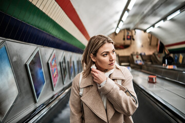 Young beautiful woman on an escalator in the train station.