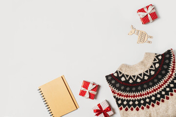 Fashion flat lay knolling with cozy sweater and gift box on white background