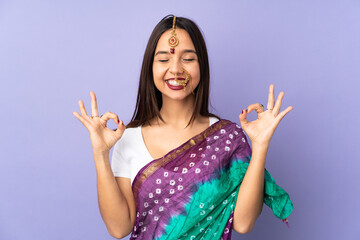 Young Indian woman isolated on purple background in zen pose