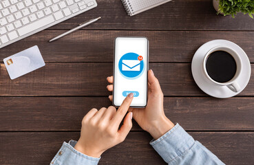 Poster - Flat lay with young woman using email application to manage her incoming messages on cellphone at office desk, closeup