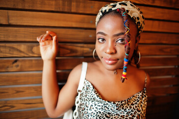 Wall Mural - Lovely african american woman with dreadlocks in leopard outfit at cafe. Beautiful cool fashionable black young girl indoor.