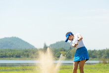 Golfer Woman Chip Golf Ball Out Of A Sand Trap. People Swing And Hitting Golf Course Is On The Fairway.  Hobby In Holiday And Vacations On Club Golf. 