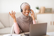 © Prostock-studio - Online education. Young black female teacher in hijab having video lesson with students, using laptop webcam indoors