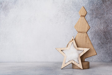 Decorative wooden Christmas tree and star on a light gray background. Zero waste concept.