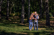 © Aleksandr - Mom kisses her daughter sitting in her father's arms. The family is resting in nature. Summer sunny day. Copy space.