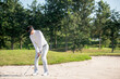 © freebird7977 - Asia Golfer man hitting out of a sand trap. The golf course is on the sand.  Hobby in holiday and vacations on club golf.