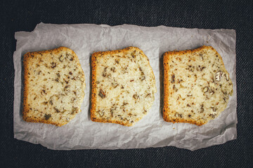 Sliced walnut bread on rustic paper.