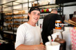 © Bec Hannaford/Austockphoto - Smiling young man at work at cafe