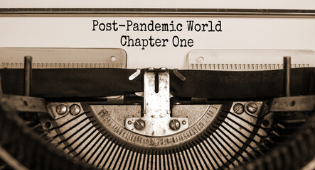 Text 'post-pandemic world chapter one' typed on retro typewriter. Business and post-pandemic covid-19 concept. Sepia effect.