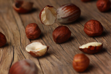 Wall Mural - hazelnuts falling on a structural table made of cracked wood