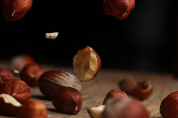 Wall Mural - delicious hazelnuts falling on a dark background