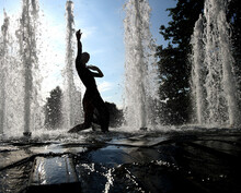 Silhouette Woman Dancing By Splashing Water In Fountain