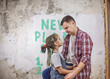 © Maria - Father with kids repairing room together, unhanging wallpaper and planning new year on wall