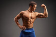 Topless male fitness model flexing biceps