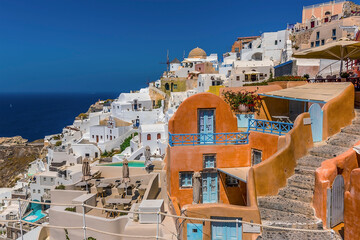 Wall Mural - Buildings and steps wind down the hillside in the village of Oia, Santorini in summertime