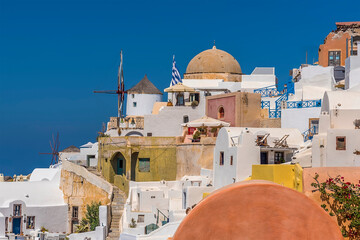 Wall Mural - The windmills and domes in the village of Oia, Santorini contrast against a deep blue sky in summertime