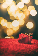 Close-up Of Christmas Present Against Illuminated Defocused Lights At Night