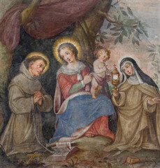  A fresco of the Virgin Mary with Infant Jesus among Saint Francis of Assisi and Saint Clare. The 