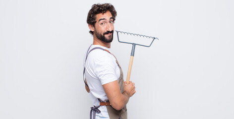 Wall Mural - young man smiling gleefully, feeling happy, satisfied and relaxed, with crossed arms and looking to the side