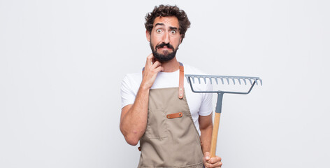 Wall Mural - young man feeling stressed, frustrated and tired, rubbing painful neck, with a worried, troubled look